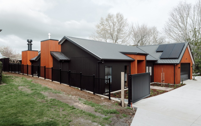 JSC's Alaskan Yellow Cedar vertical shiplap cladding coated in JSC Scumble Desert contrast against black cladding by Transform Construction